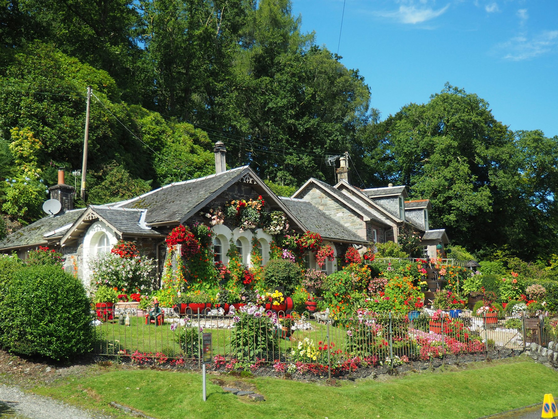 Home with a cut lawn and full flower beds along the fence